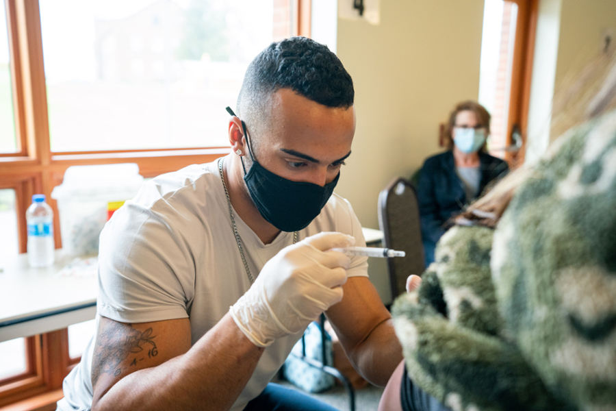 Austin Kemp administering vaccine